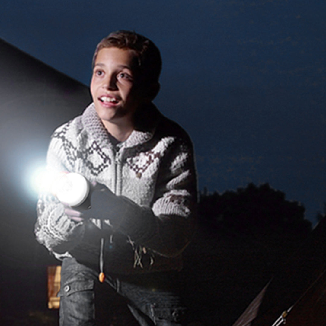 Camper enjoying evening outdoors with reliable LED lantern providing essential lighting for activities