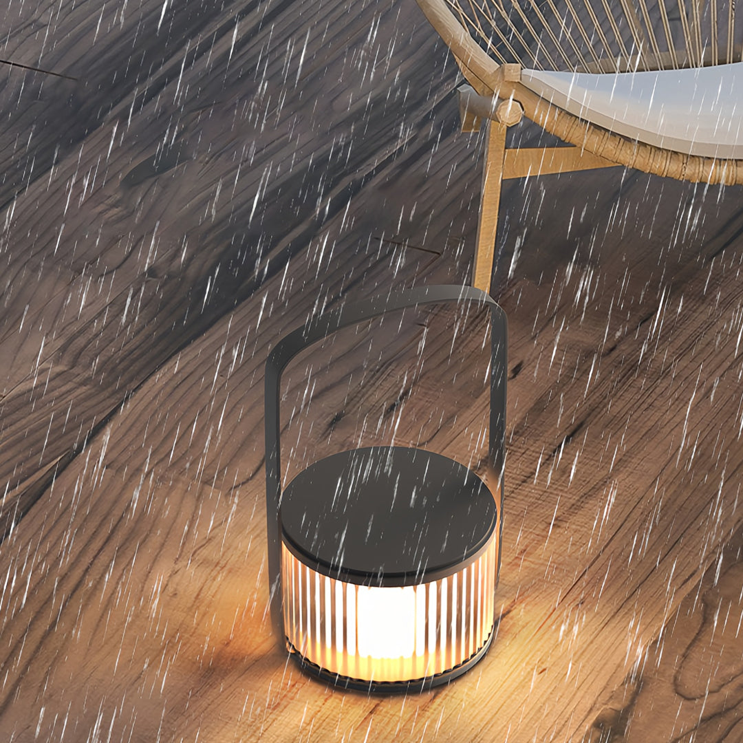 A hanging camping LED lantern illuminating falling snow, creating a cozy winter atmosphere.