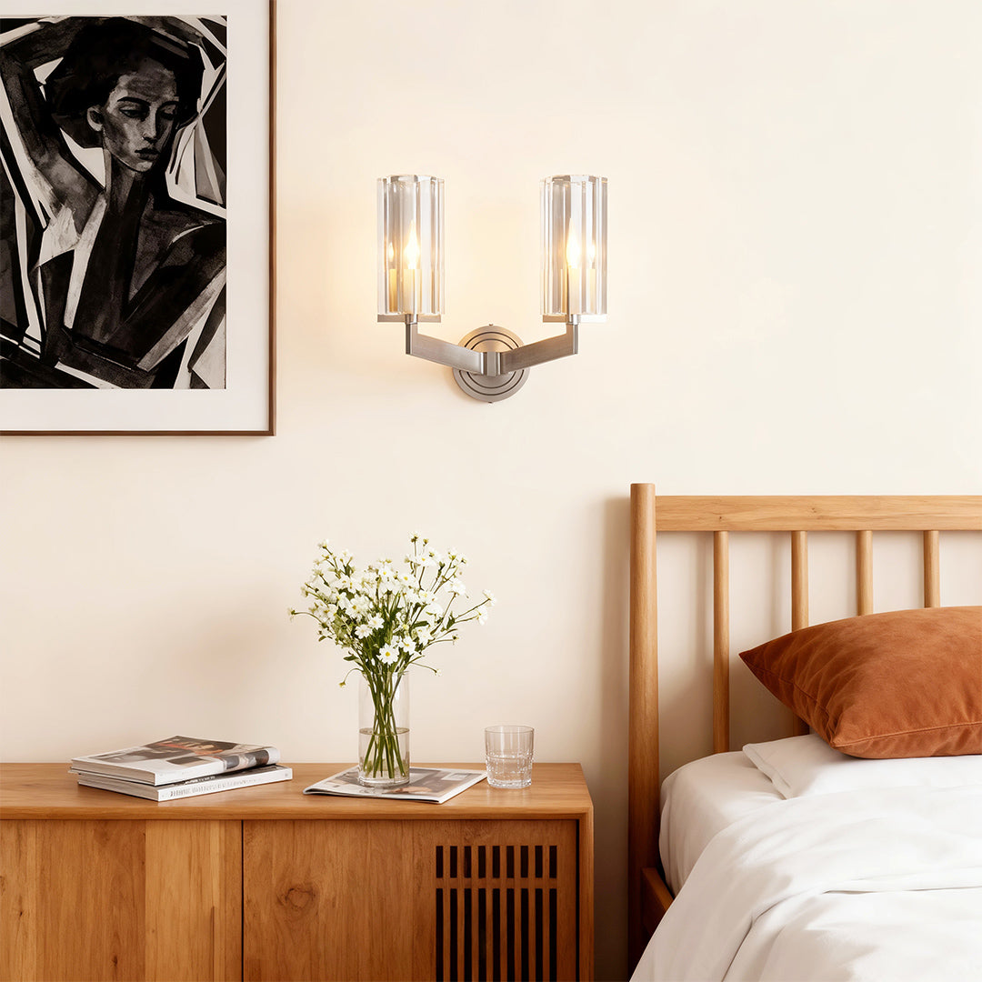 Modern luxury chandeliers illuminating cozy bedroom with wooden furniture and modern artwork