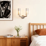 Modern luxury chandeliers illuminating cozy bedroom with wooden furniture and modern artwork
