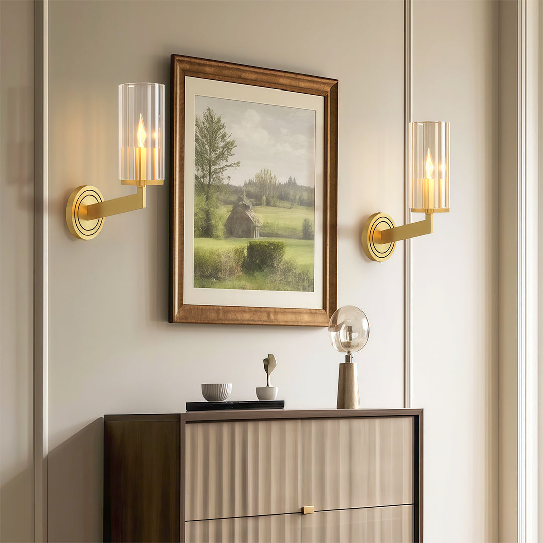 Candle chandeliers flanking artwork in elegant hallway with neutral console and decorative items