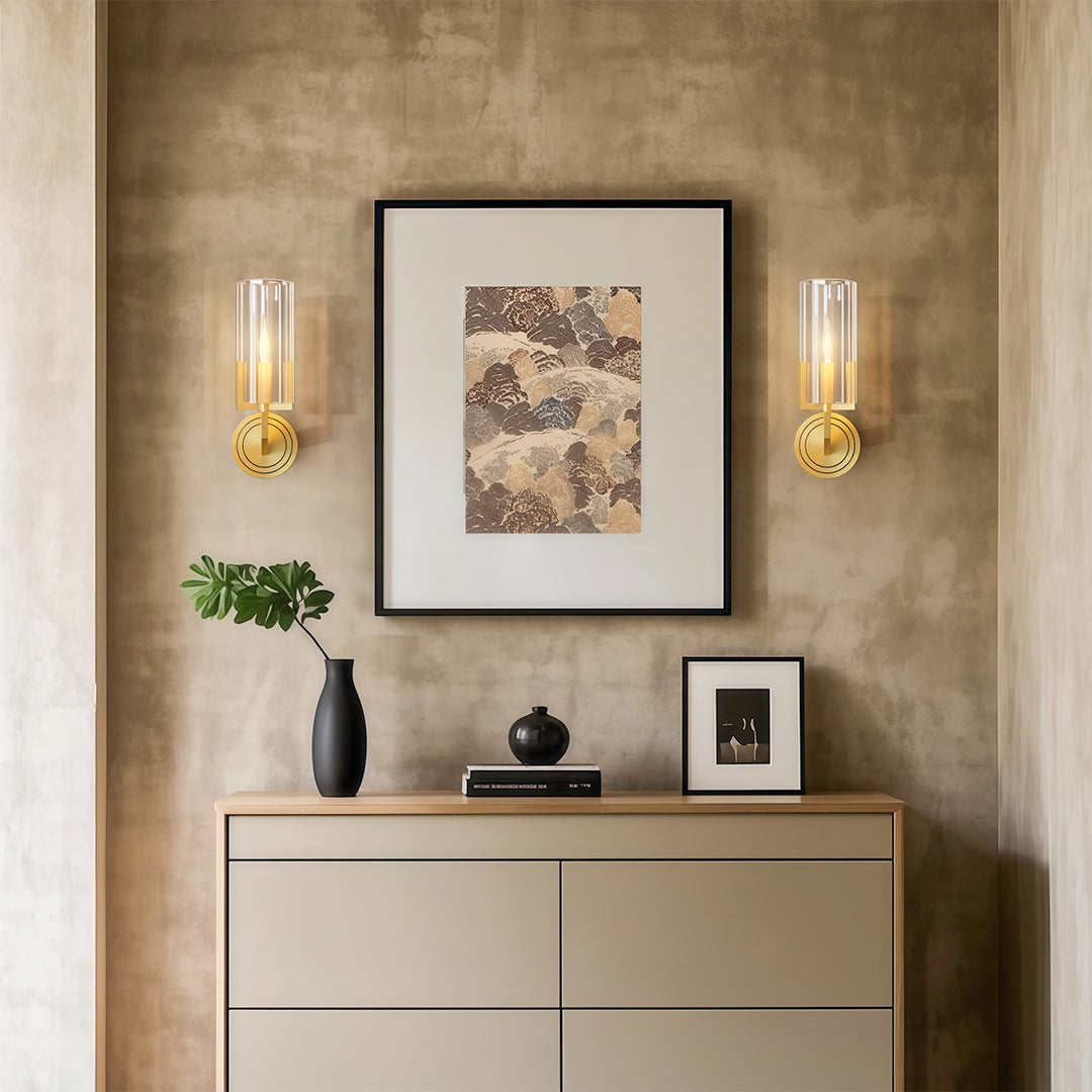 Candle chandeliers pair flanking framed artwork above console in neutral entryway