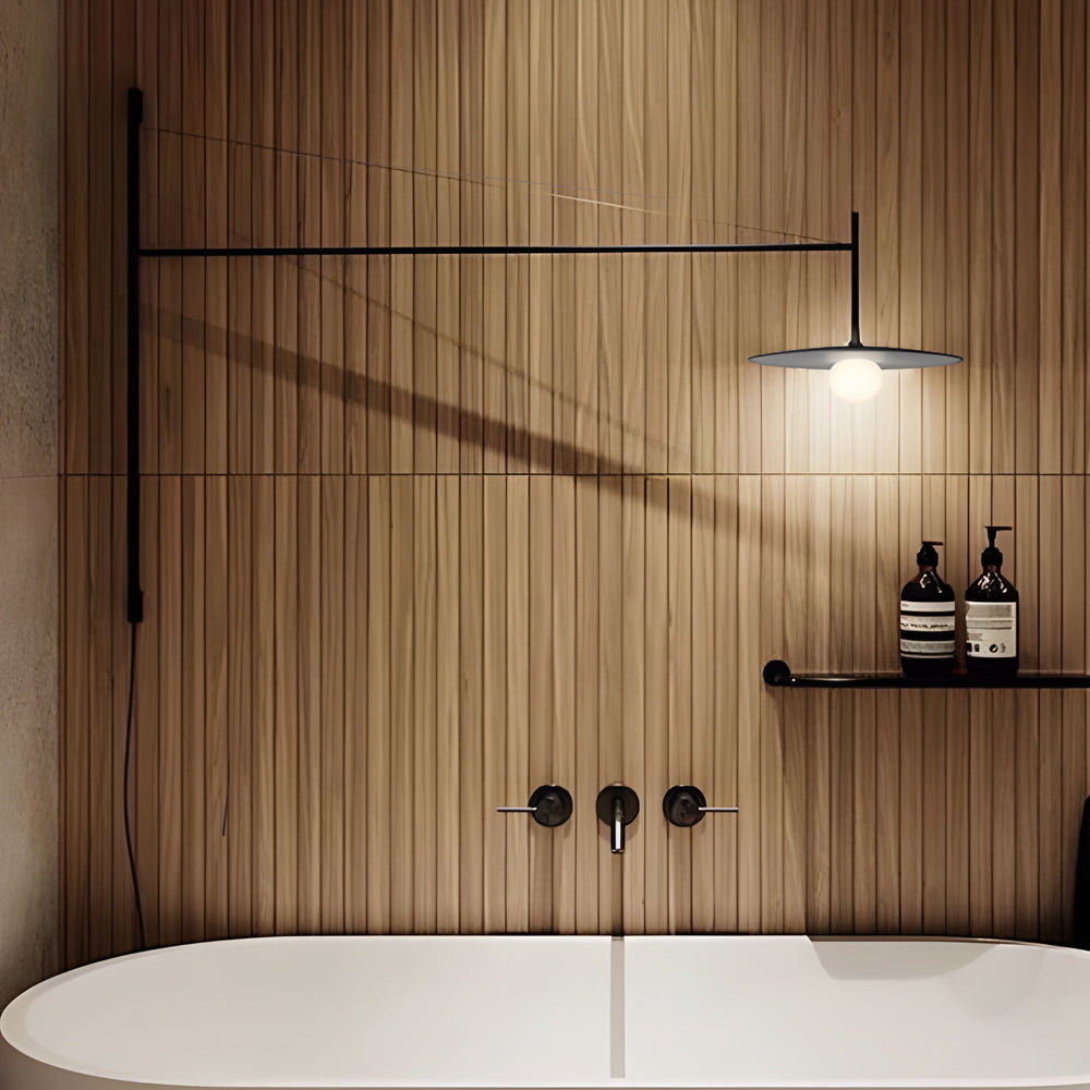 Contemporary cantilever wall lamp above a bathtub, combining functional lighting with warm wood wall textures.