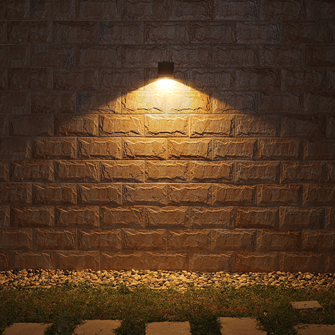 Close-up view of bronze outdoor light fixture showing curved arm and mounting details