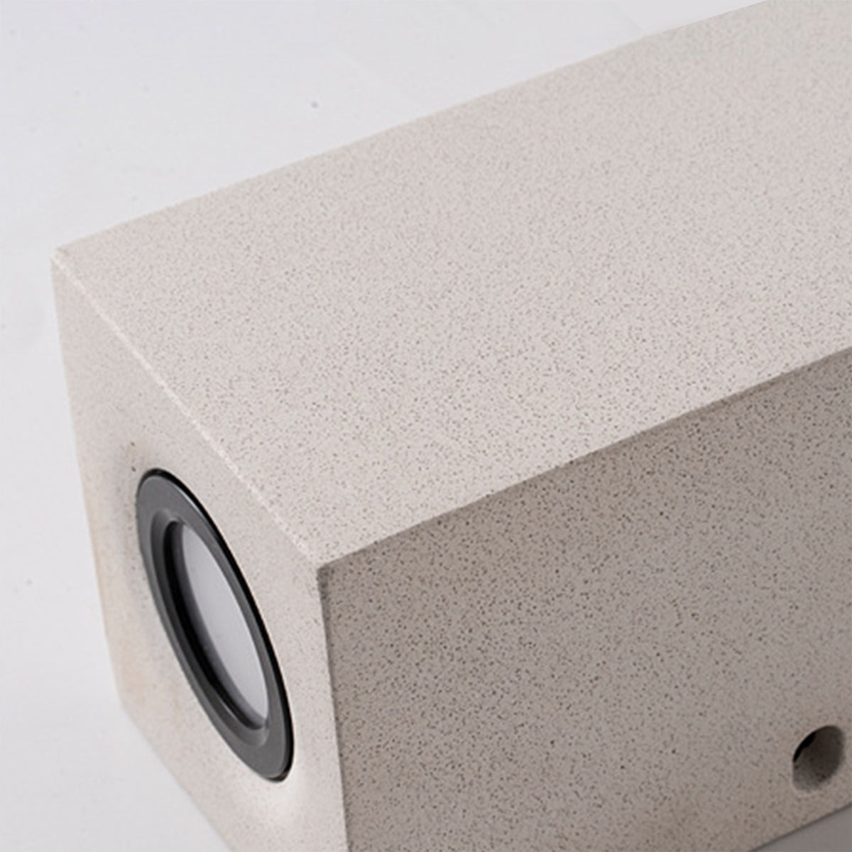 Close-up detail of square concrete outdoor wall light with circular LED opening and modern design