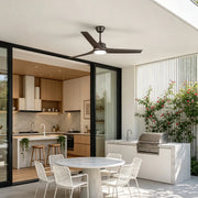 Ceiling fan with light above a modern covered patio featuring an outdoor kitchen and dining area.