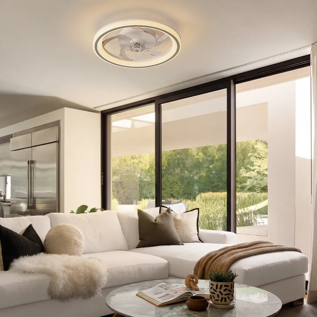 Ceiling fans with light fixtures installed in a modern living room with glass doors and a white sectional sofa.