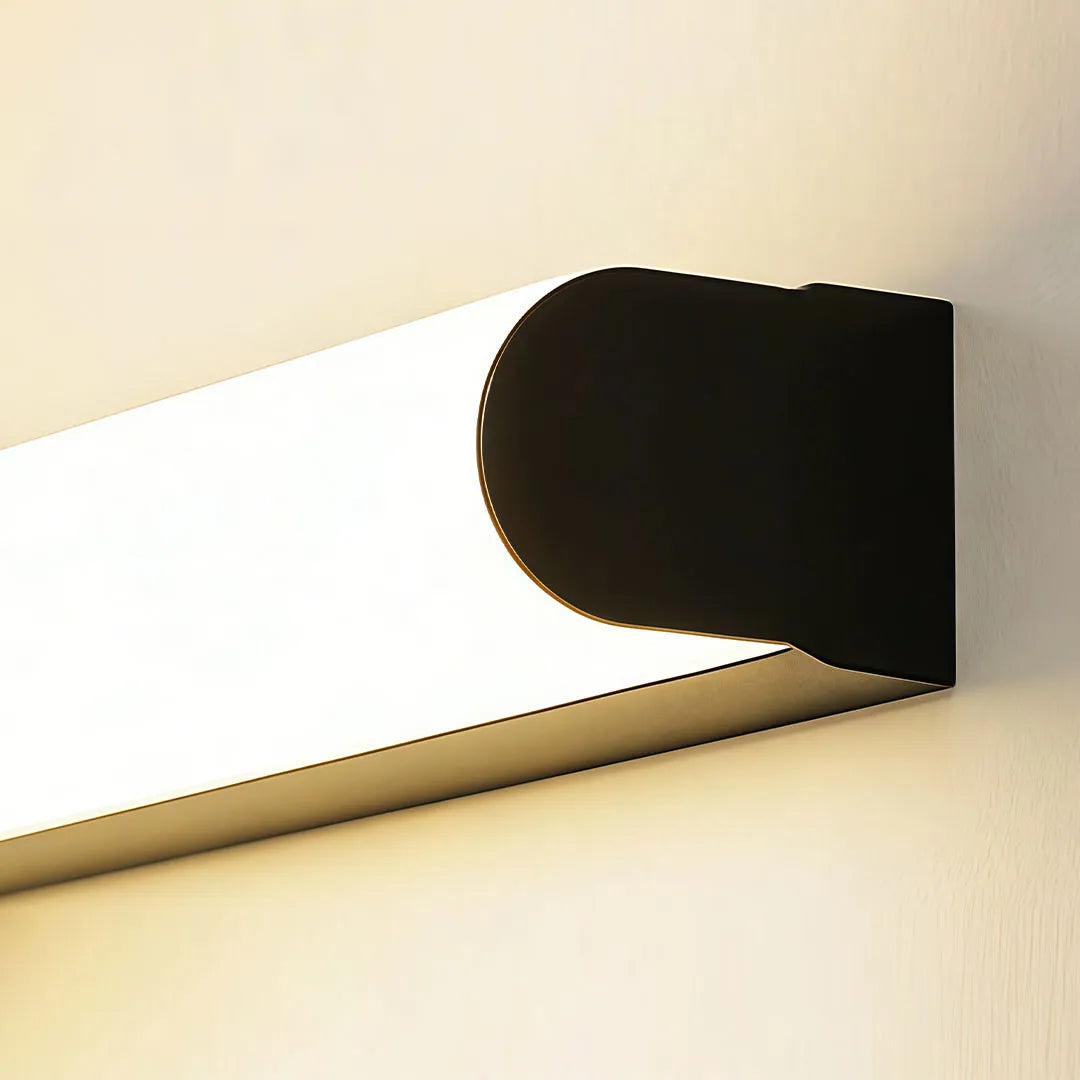 Close-up of a ceiling linear light featuring a black end cap and warm frosted LED diffuser.
