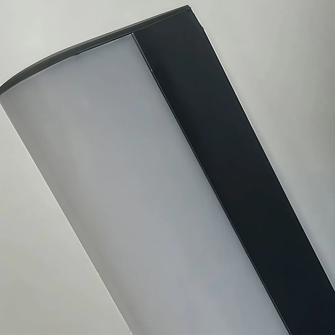 Close-up of a ceiling linear light with a slim black rectangular frame and wide frosted diffuser.