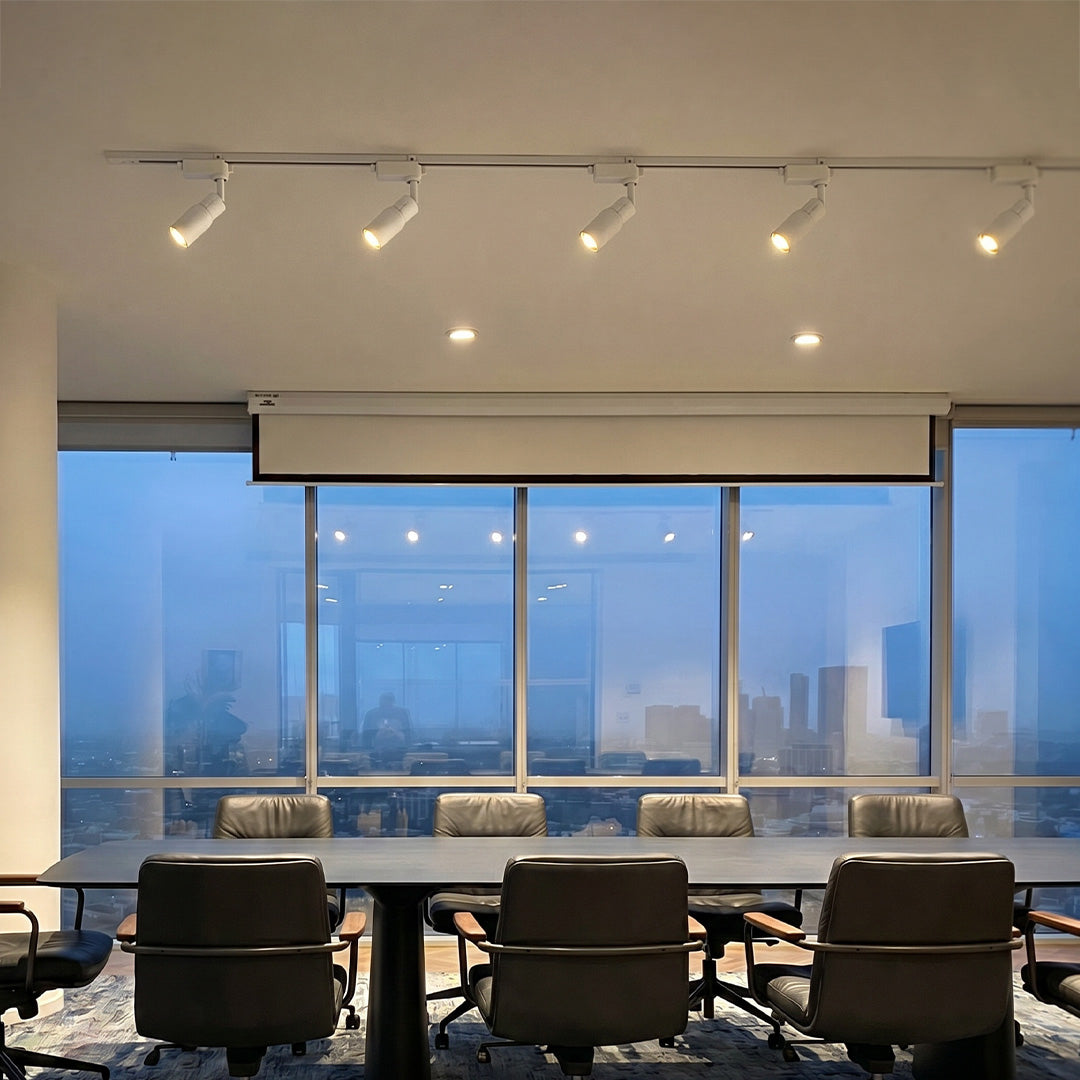 Modern ceiling rail spotlights illuminating a luxury conference room with adjustable track lighting system.