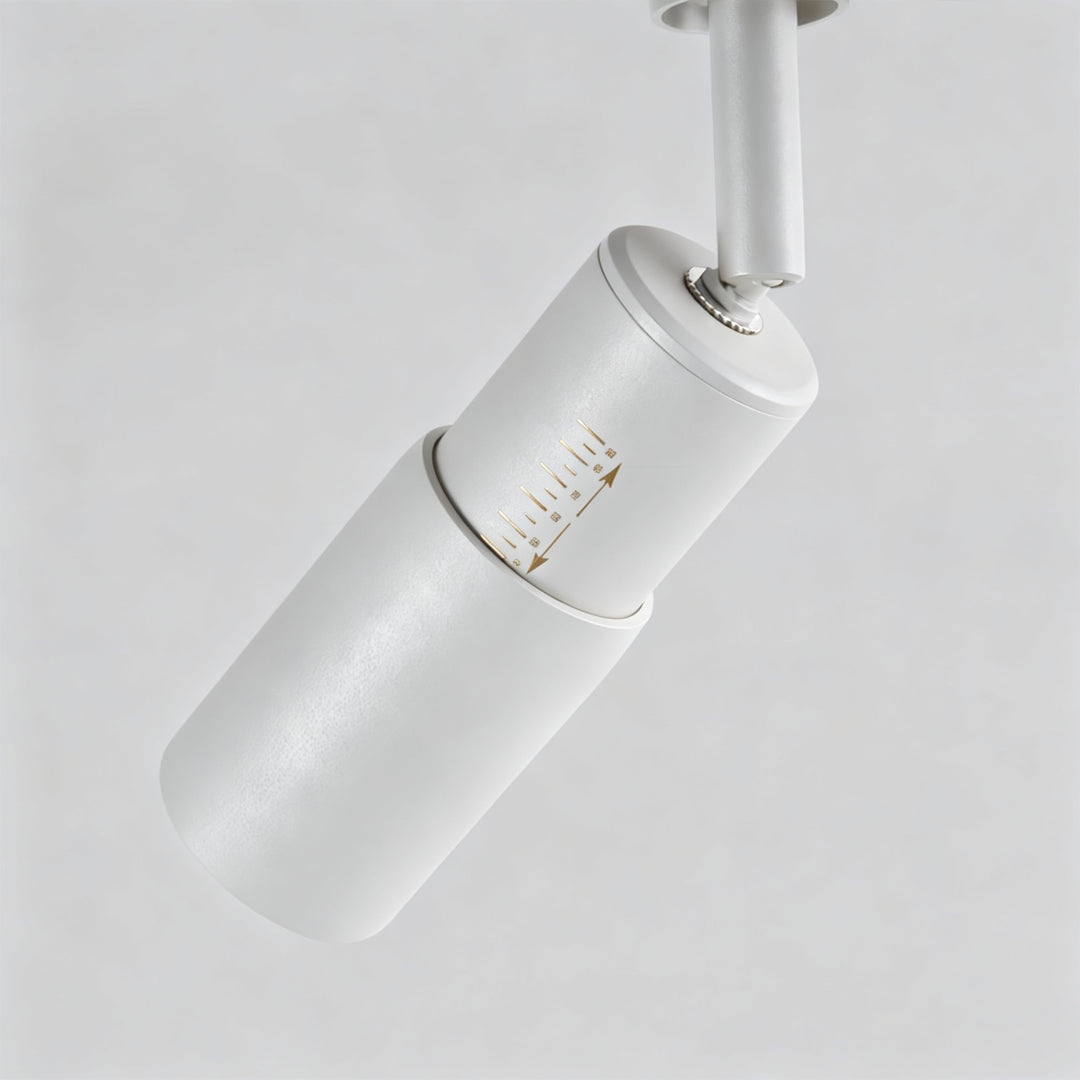 Close-up detail of ceiling rail spotlights featuring white cylindrical spotlight housing and track mount.