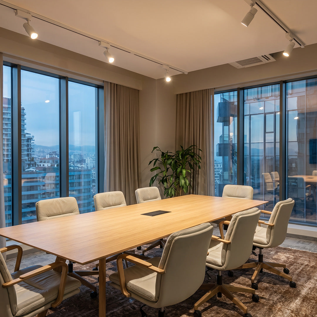Contemporary ceiling rail spotlights featured above a modern meeting room with warm ambient lighting.