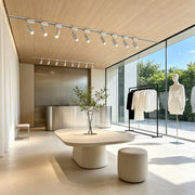 White ceiling rail spotlights installed in a contemporary retail showroom with directional track lighting.