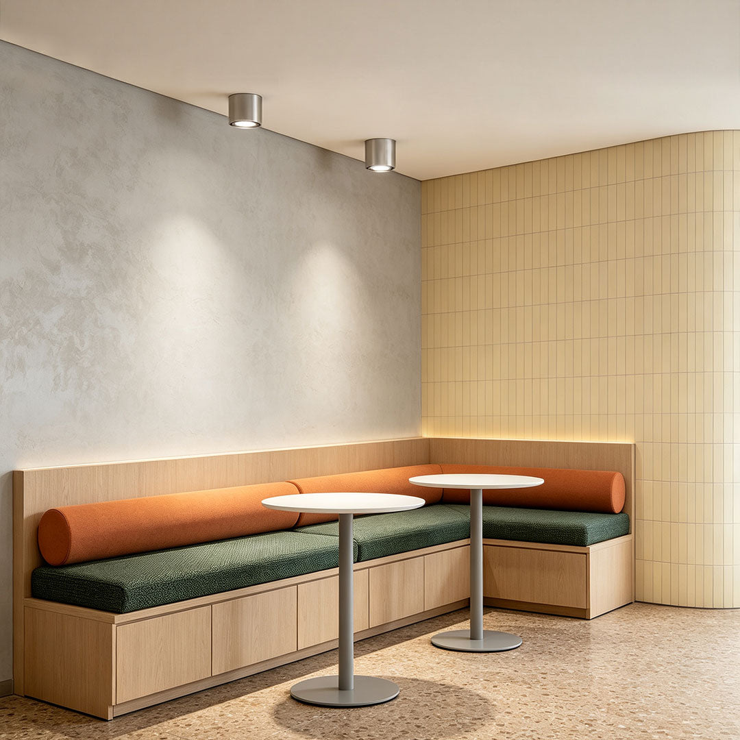 Ceiling spotlight illuminating a modern café seating area with warm focused LED lighting.