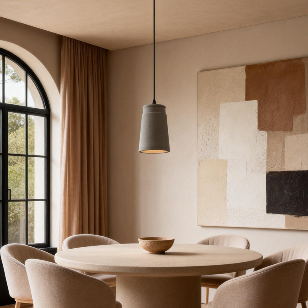 Cement look pendant lights illuminating a modern dining room with warm ambient glow.