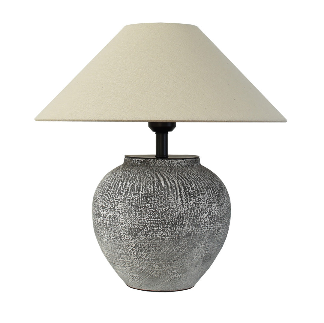 Ceramic base table lamp product view on a white background with a rounded base and tapered linen shade.