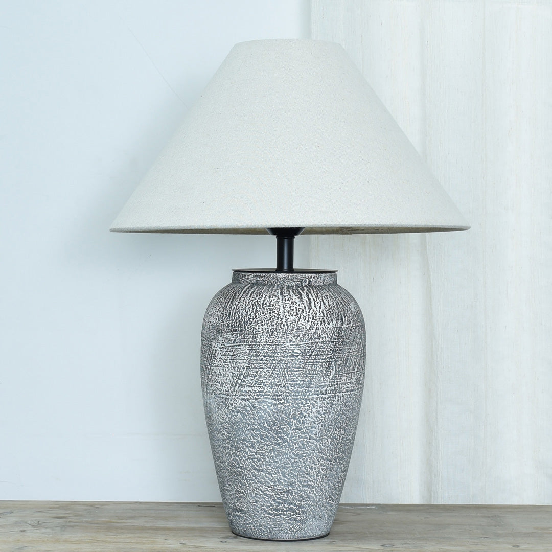 Ceramic base table lamp product image on a white background with a textured gray ceramic base and beige shade.