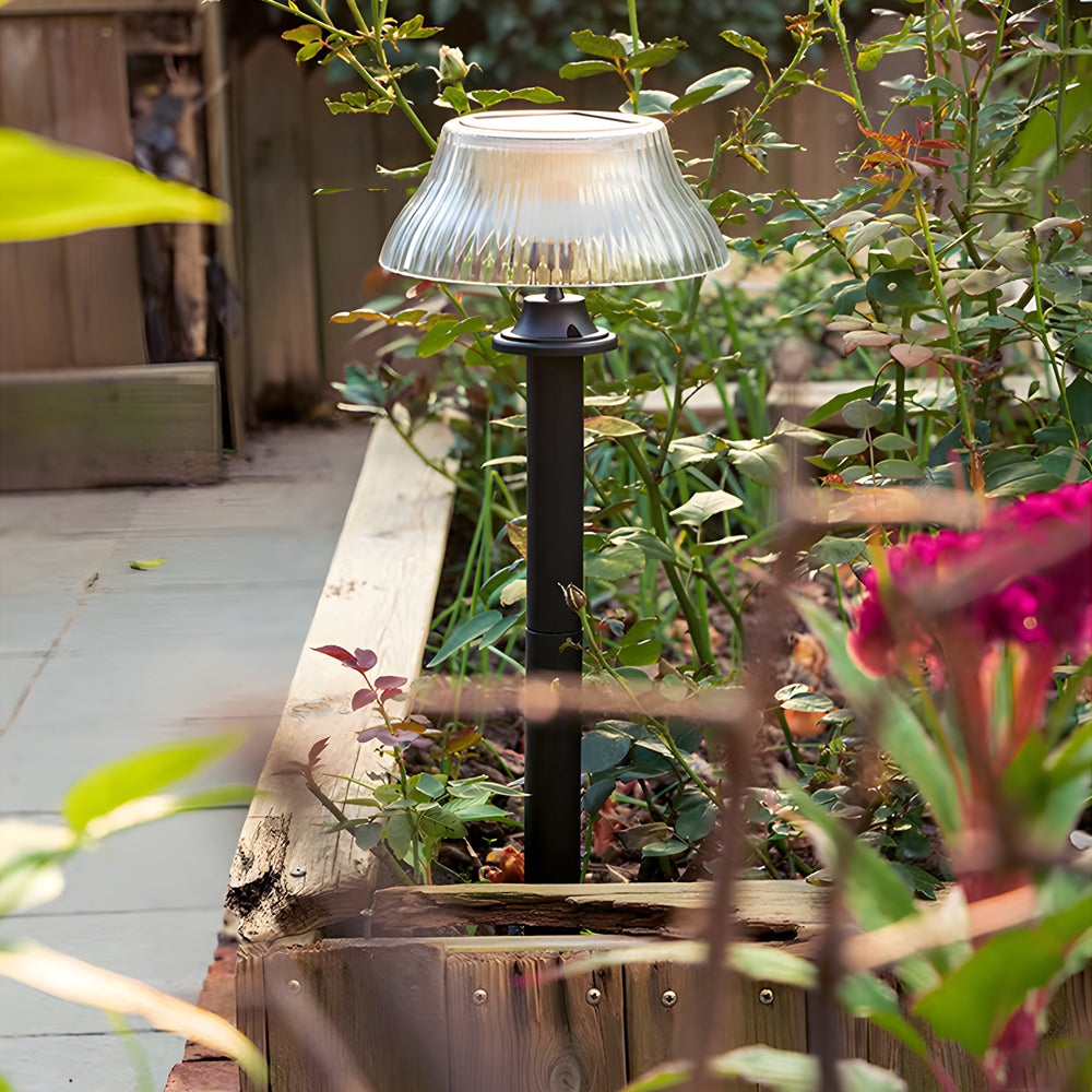 Garden bed enhanced with solar stake light providing warm illumination among colorful flowering plants