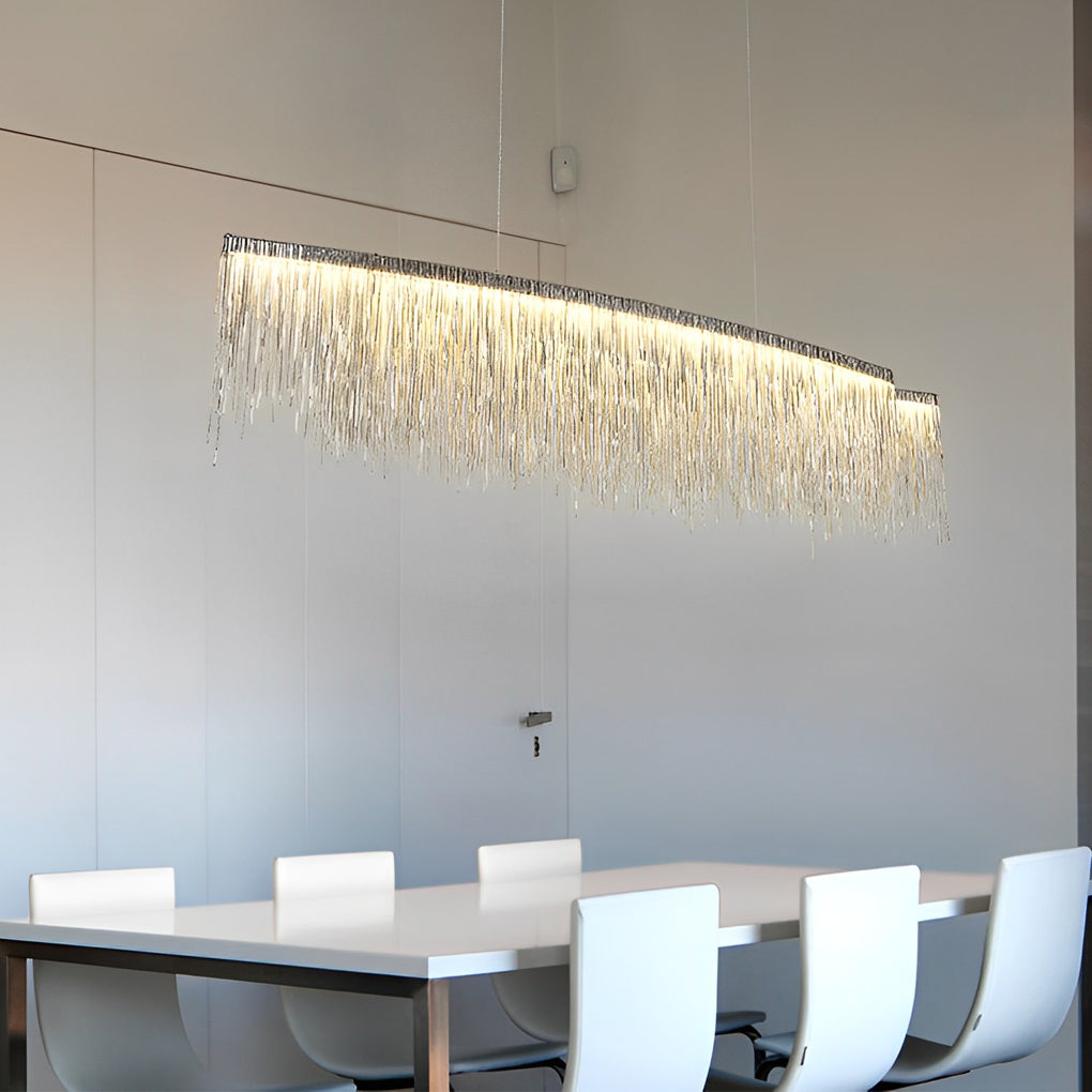 Chain tassel chandelier with a gold finish, providing warm light in a dining room.