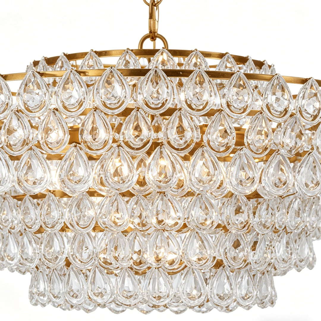 Chandelier lighting crystal close-up showing layered glass drops and gold frame detail.