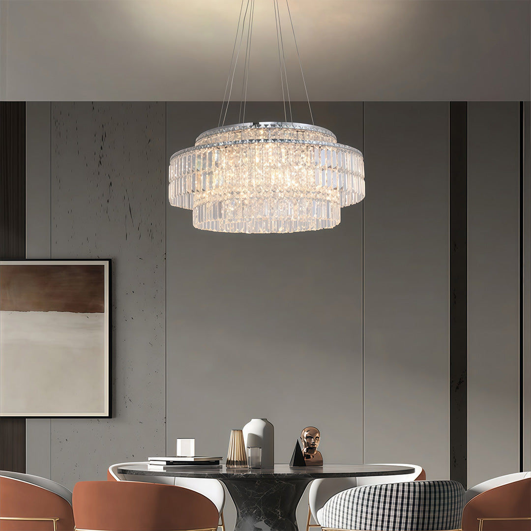 Chandelier with round crystals creating ambient lighting in grey contemporary dining room with marble accents.