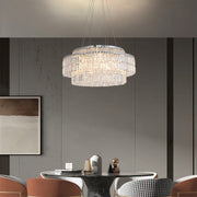 Chandelier with round crystals creating ambient lighting in grey contemporary dining room with marble accents.