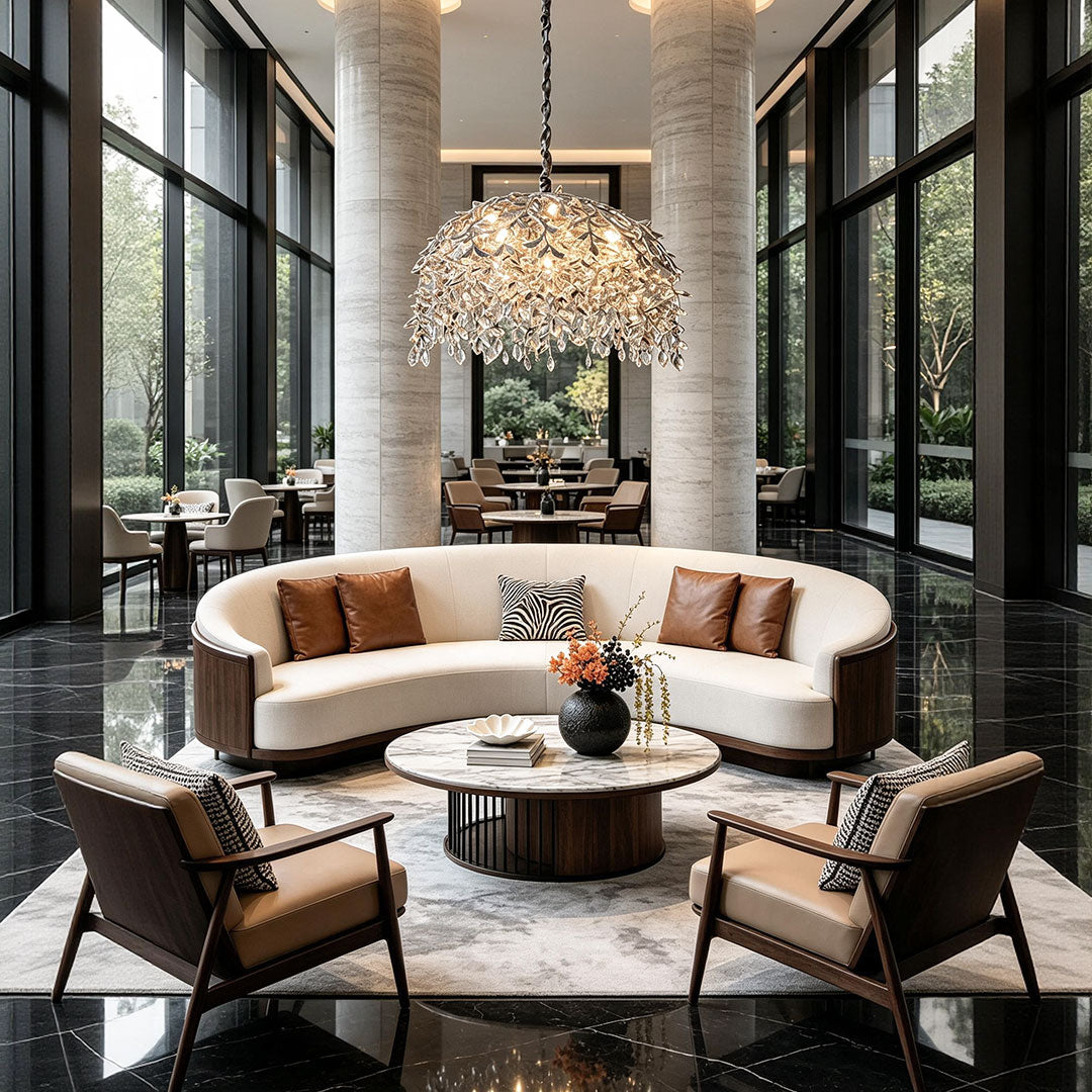 Chandelier with crystal hanging in a grand double-height living room with a curved sofa and floor-to-ceiling windows.