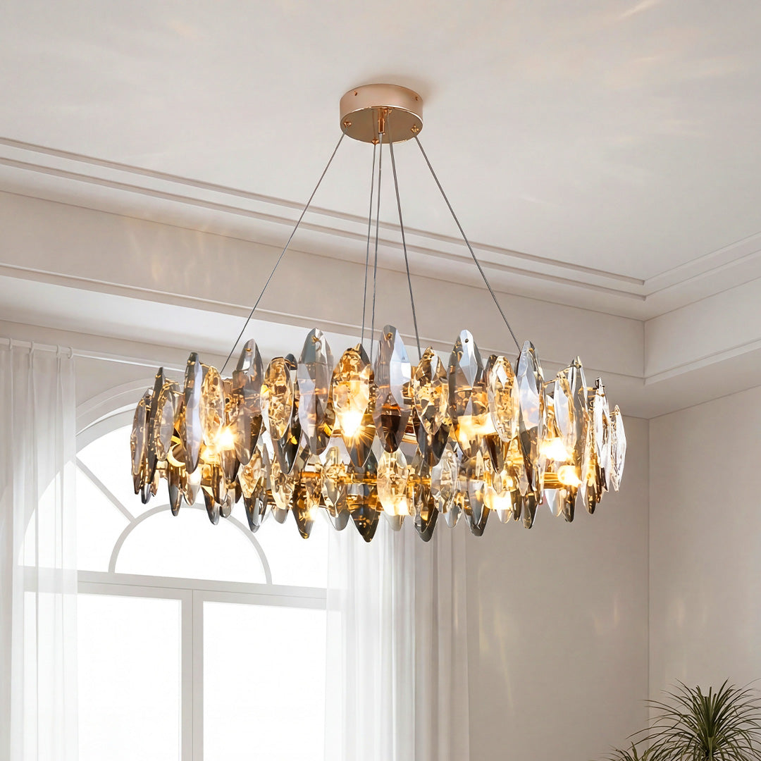 Elegant chandelier with crystals featuring smoky leaf-shaped glass in a bright white room.