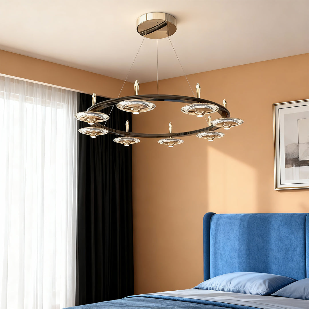 Chandelier with round crystals creating focal point in bedroom with terracotta walls and vibrant blue upholstered chair