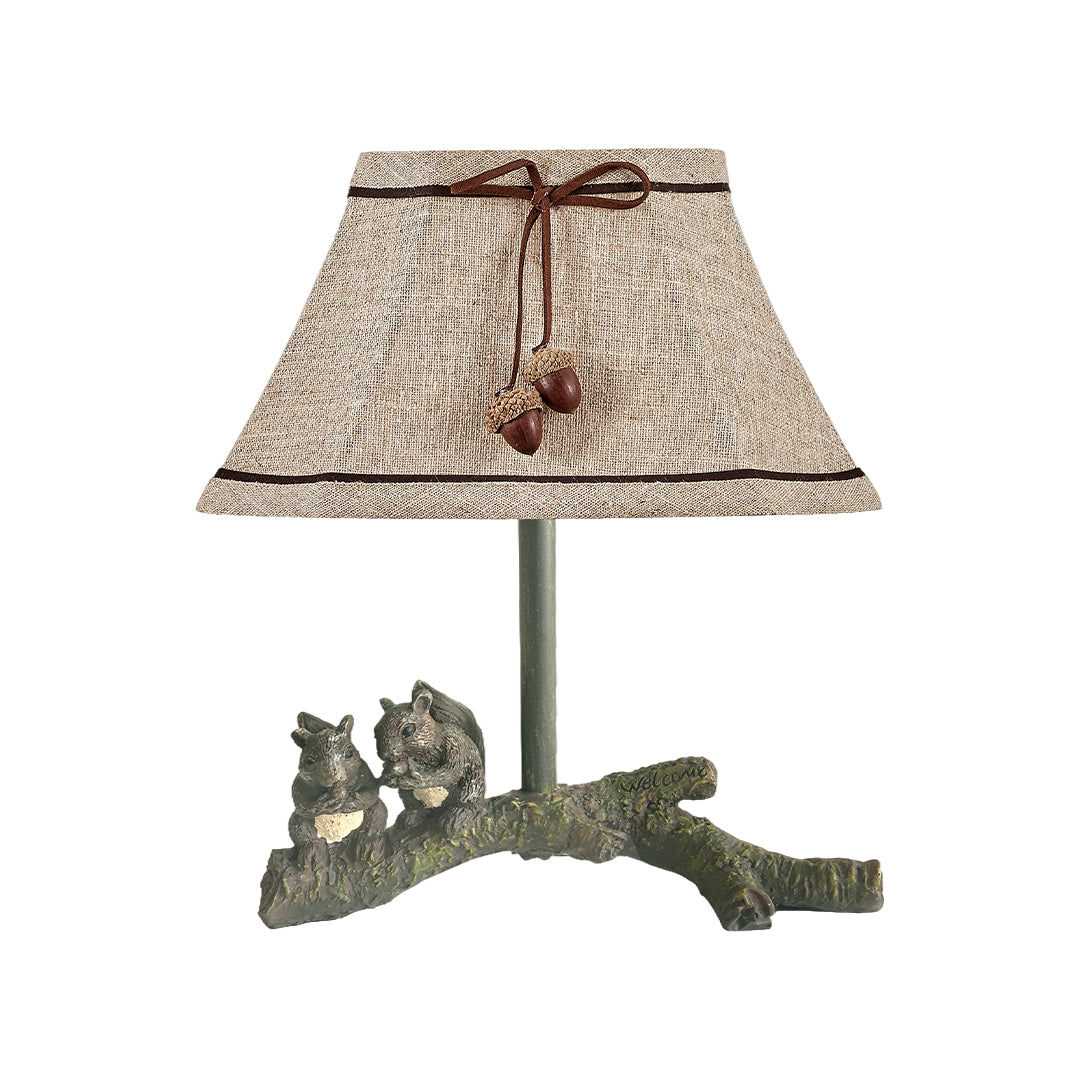 Charming squirrel table lamp featuring a textured, light brown woven shade and a rustic resin base with two squirrels on a branch.