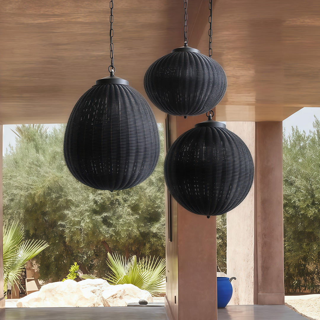 Black woven pendant lights suspended above a chic dining table, creating a striking contrast with the decor.