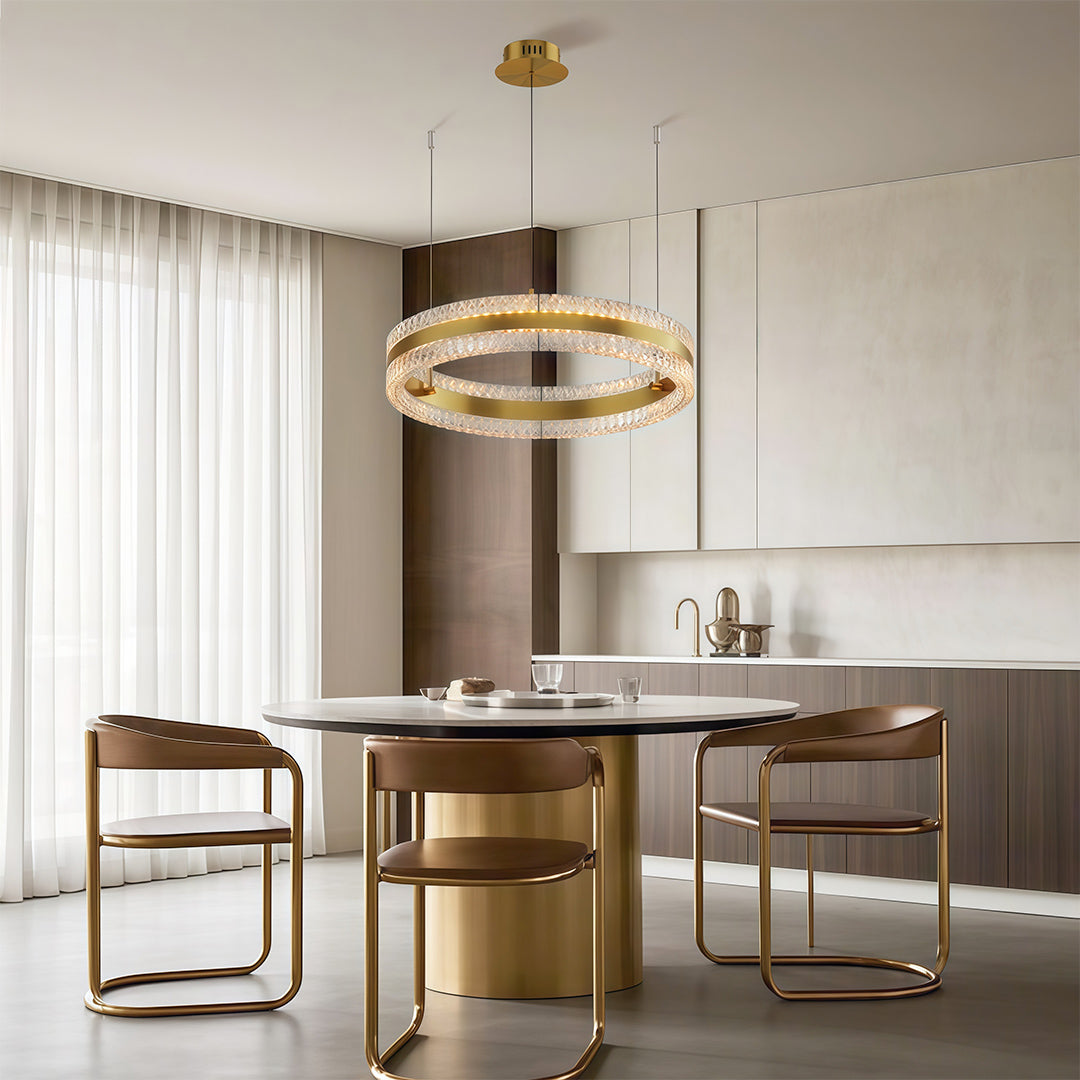 Chic modern circular chandelier with a gold finish, suspended above a round dining table.