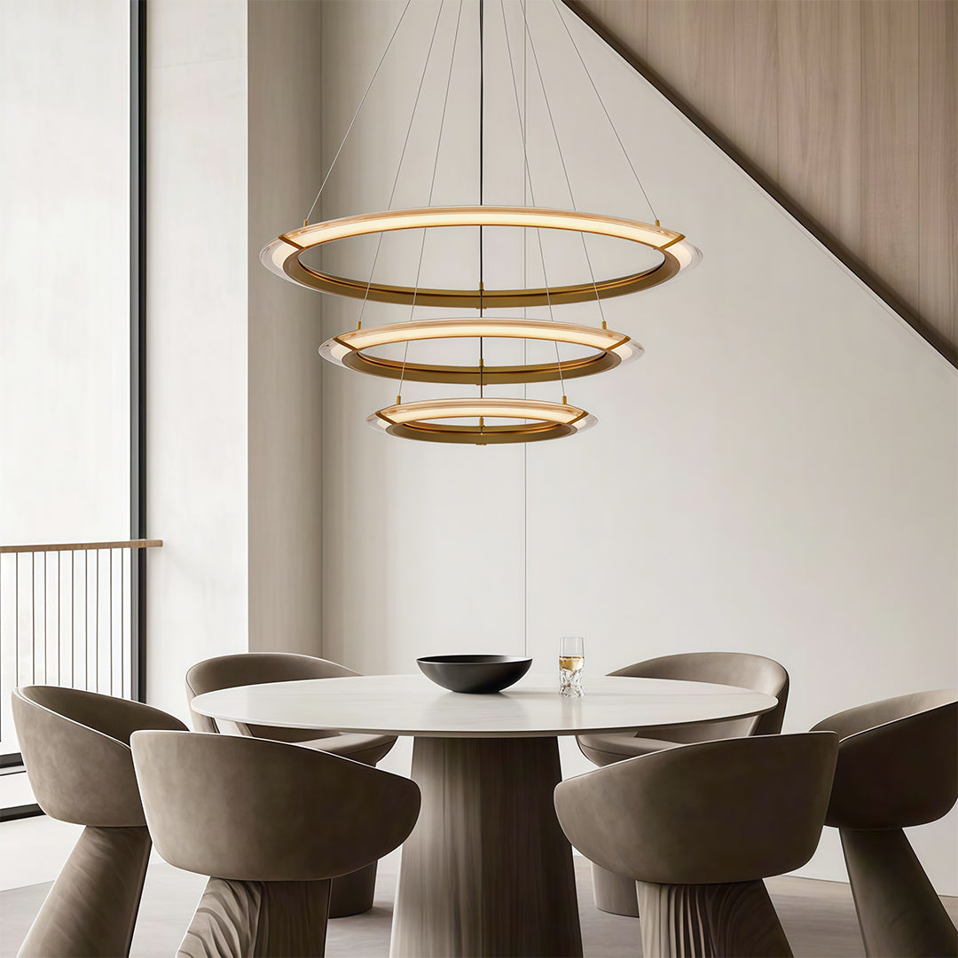 Chic modern round chandelier with a gold finish, illuminating a contemporary dining area.