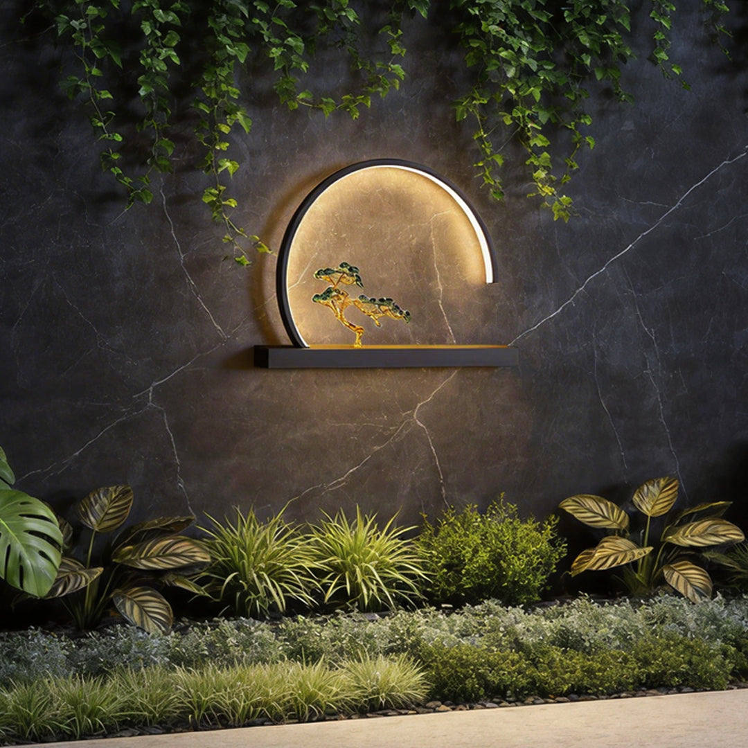 Chinese Greeting Pine Outdoor Wall Light with a circular design, illuminating a garden wall.