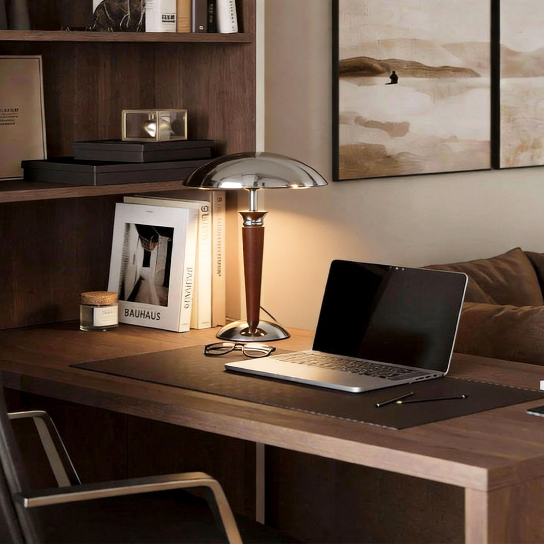 Chrome mushroom lamp on a wooden desk with laptop and books, perfect for home office lighting.