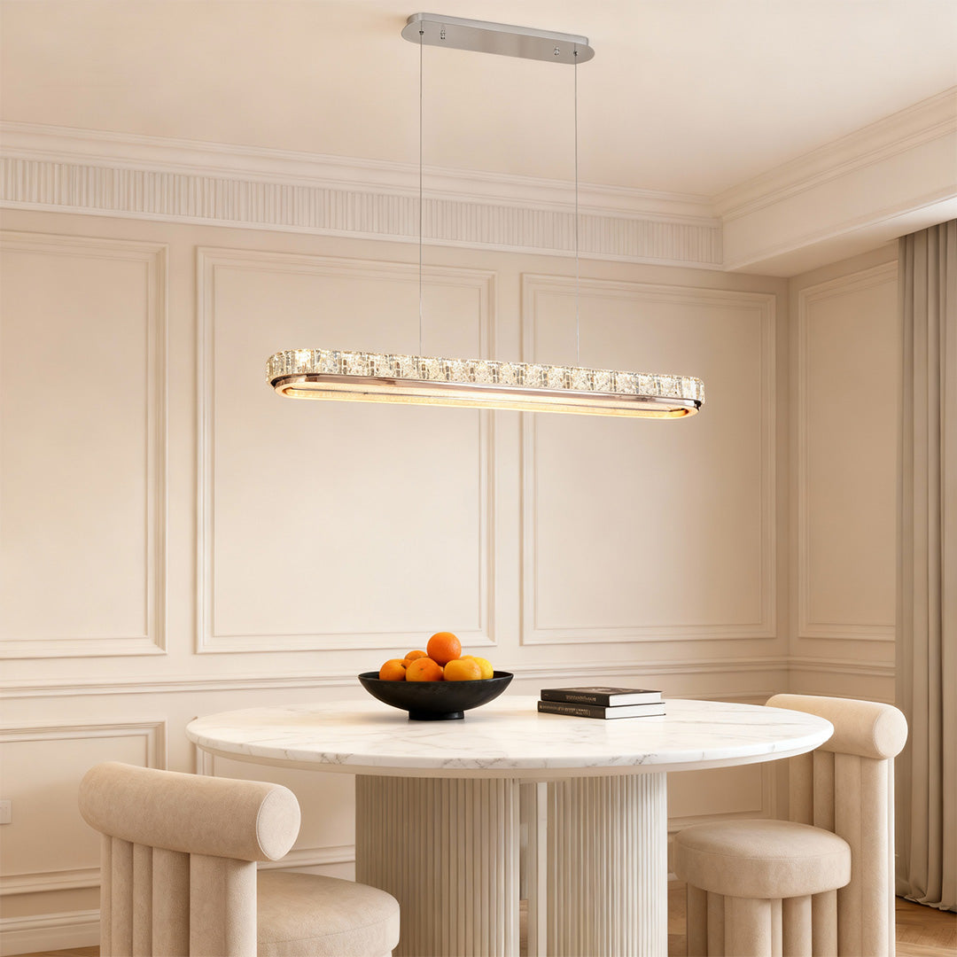 Chrome pendant light in a contemporary dining room with a round table, adding a touch of elegance to the space.