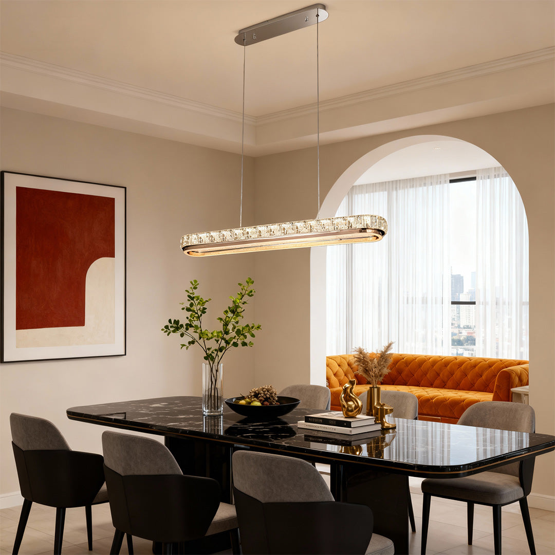 Chrome pendant light in a dining area with dark chairs and a white table, enhancing the ambiance with subtle lighting.