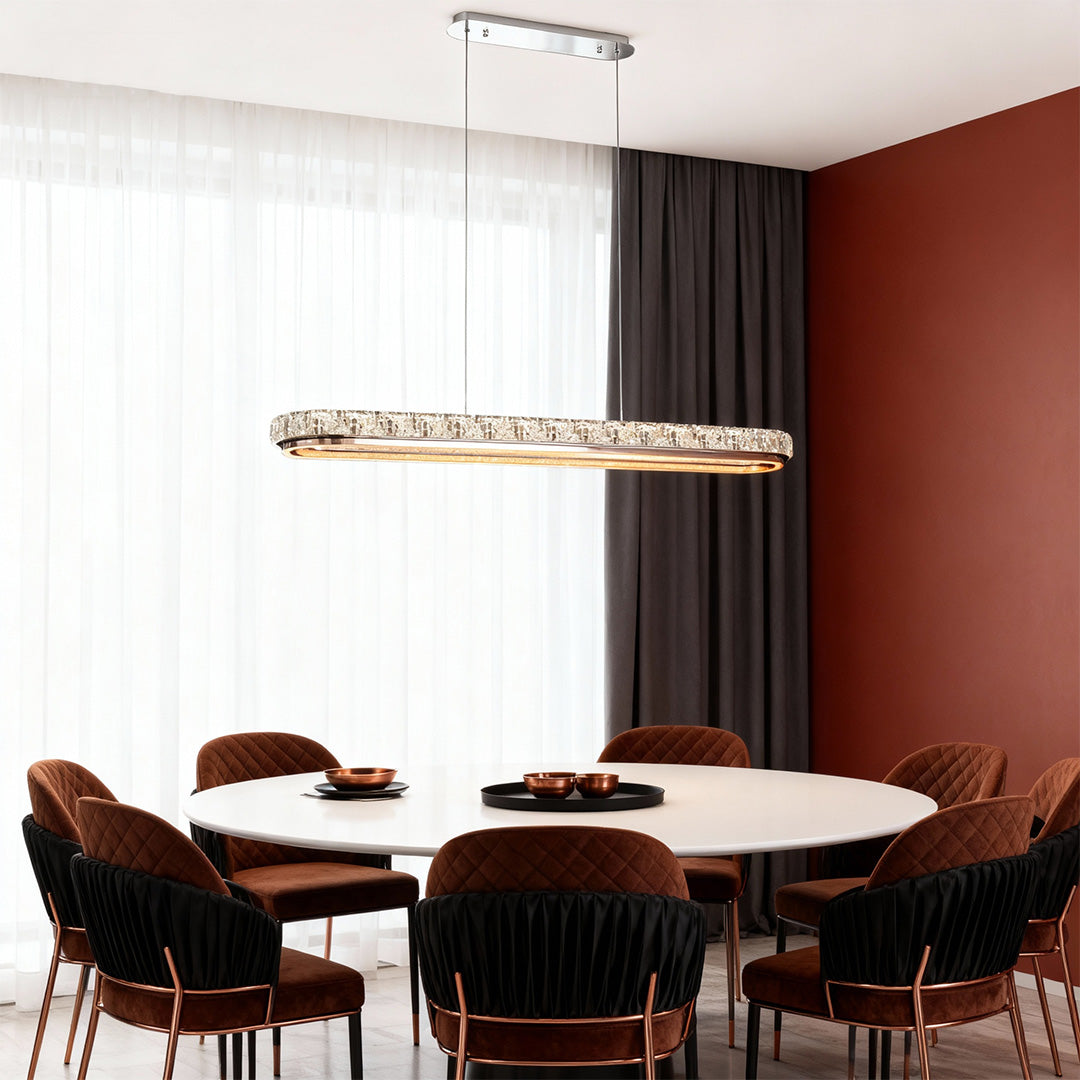 Chrome pendant light in a dining room with a neutral color palette, providing a warm and inviting glow.