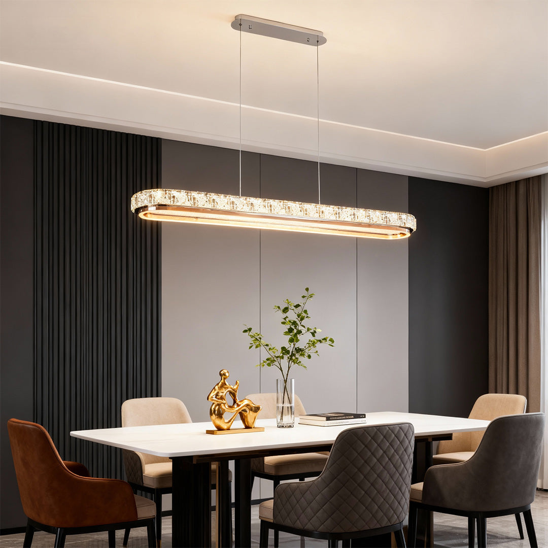 Chrome pendant light installed in a modern dining room with a white table, providing warm and inviting illumination.
