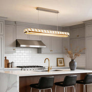 Chrome pendant lights illuminating a modern kitchen island with sleek design.