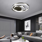 Circular ceiling light illuminating modern living space with gray sectional sofa and artwork
