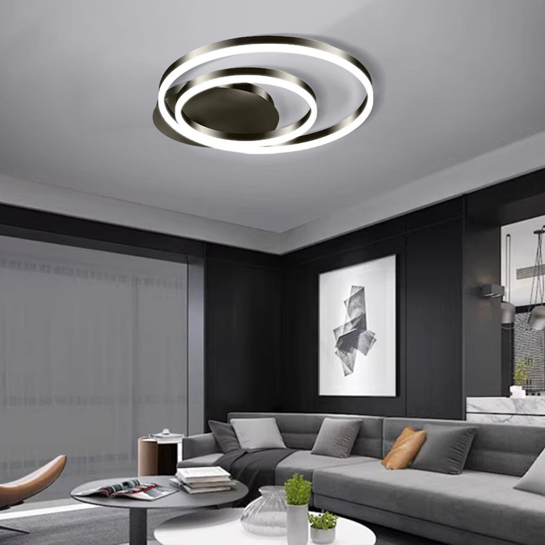 Circular ceiling light illuminating modern living space with gray sectional sofa and artwork