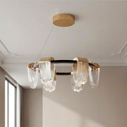 Striking circular chandelier modern design featuring a black and gold ring frame with draped textured clear glass pendants.