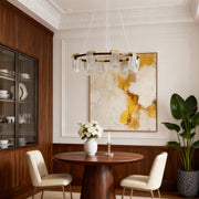 Stylish circular chandelier modern fixture enhancing a dining room with gold and crystal accents.