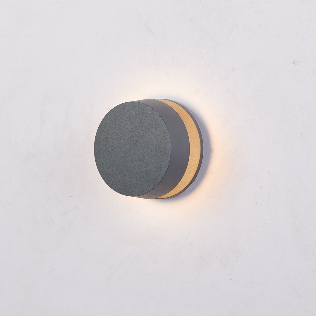 Small circular LED path light with side-mounted warm glow perfect for subtle landscape accent lighting