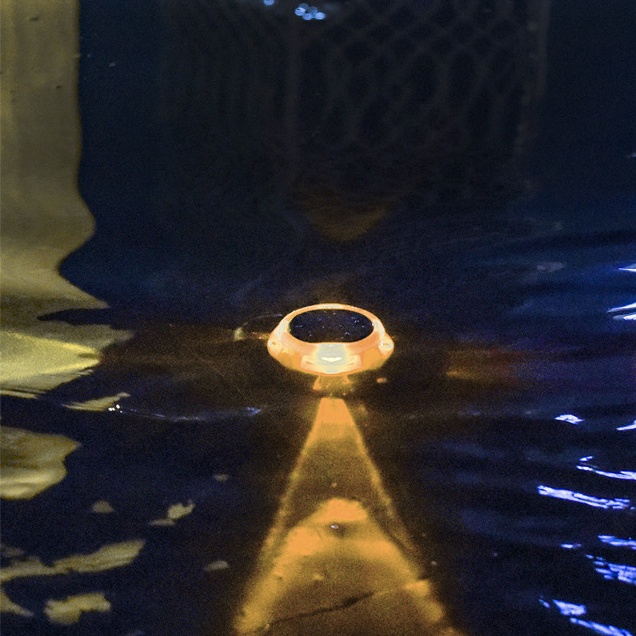 Circular solar ground light creating warm directional lighting on outdoor surface at night