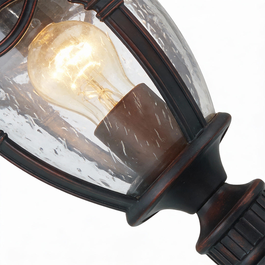 Classic gate pillar light with ribbed glass and bronze finish, providing warm illumination for driveways and entrance pathways.