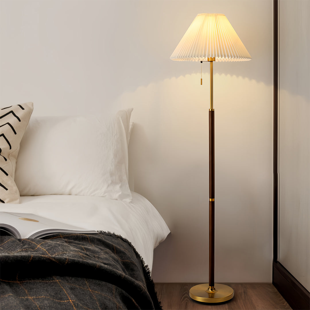 Classic floor wood lamp providing bedside lighting in elegant bedroom with neutral color palette