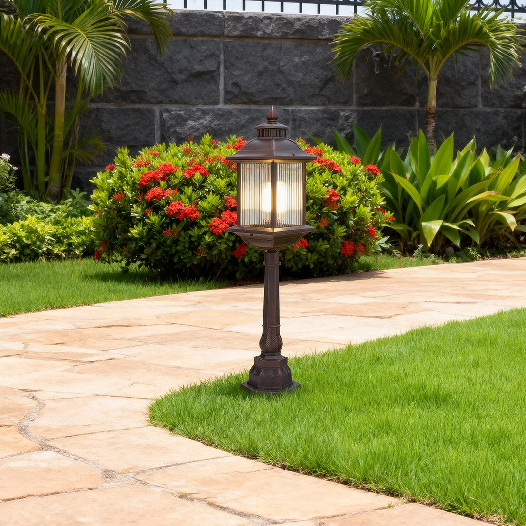 Classic LED post light fixture with decorative lantern design installed in tropical landscaped driveway