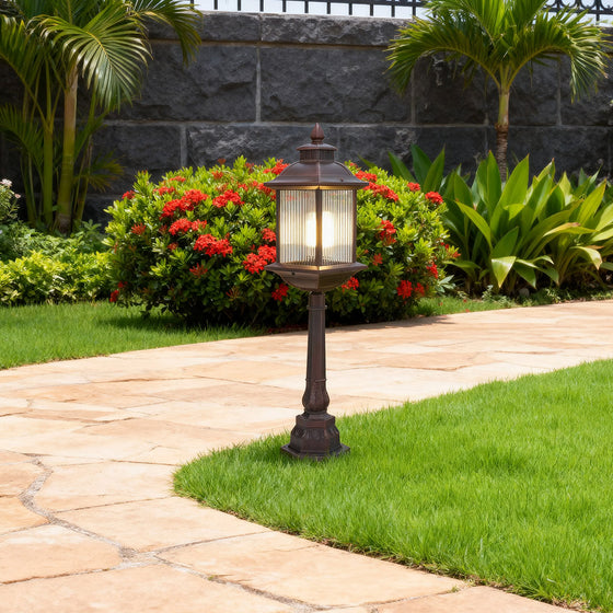 Classic LED post light fixture with decorative lantern design installed in tropical landscaped driveway